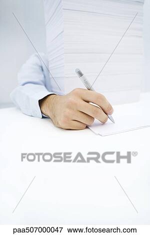 Arm reaching around massive stack of paper to write on a single sheet View Large Photo Image Stock Photo - Arm reaching around massive stack of paper to write on a single sheet. Fotosearch