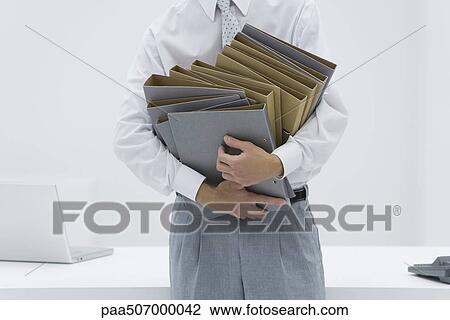 Man holding many binders, cropped view View Large Photo Image Stock Image - Man holding many binders, cropped view. Fotosearch
