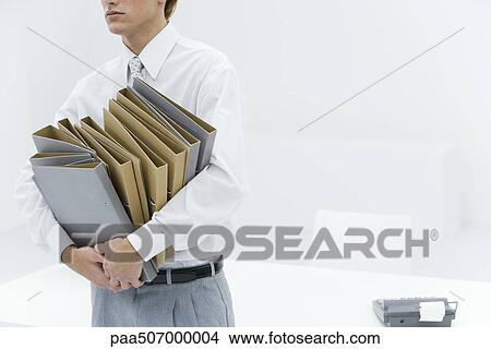 Office worker carrying many binders, cropped view View Large Photo Image Picture - Office worker carrying many binders, cropped view. Fotosearch