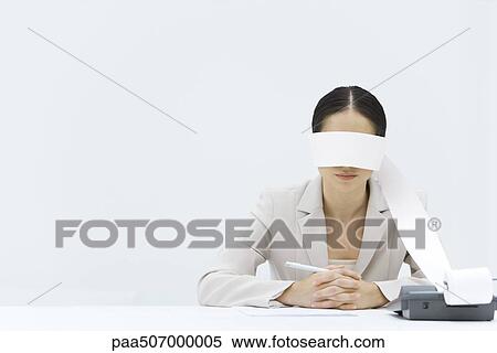Woman sitting at table with adding machine tape wrapped around her eyes View Large Photo Image Stock Photography - Woman sitting at table with adding machine tape wrapped around her eyes. Fotosearch