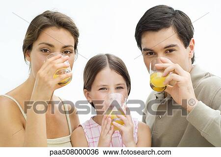 Family drinking orange juice, all looking at camera View Large Photo Image Stock Photograph - Family drinking orange juice, all looking at camera. Fotosearch