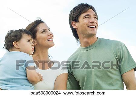 Picture - Family looking up, mother holding baby. Fotosearch