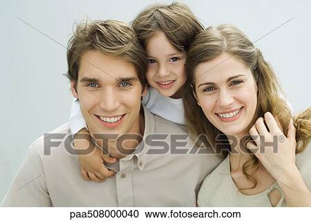 Little boy putting his arms around the shoulders of his parents, smiling at camera, portrait View Large Photo Image Stock Image - Little boy putting his arms around the shoulders of his parents, smiling at camera, portrait. Fotosearch