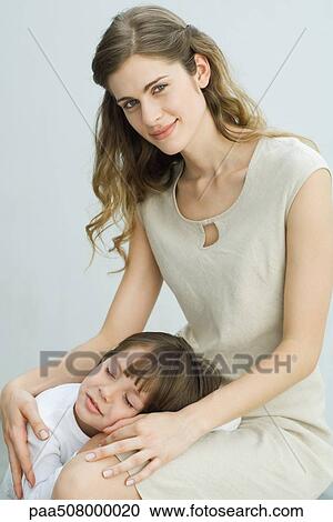 Little boy resting head on mother's lap, woman smiling at camera View Large Photo Image Stock Image - Little boy resting head on mother's lap, woman smiling at camera. Fotosearch
