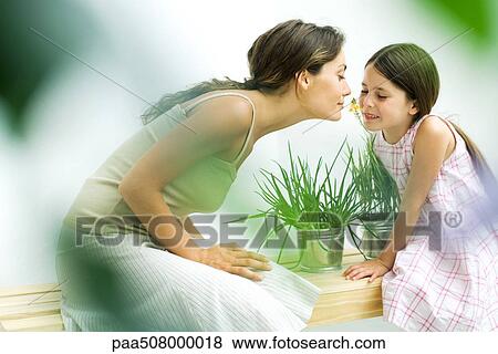 Woman and daughter smelling flower sprig together View Large Photo Image Stock Photo - Woman and daughter smelling flower sprig together. Fotosearch