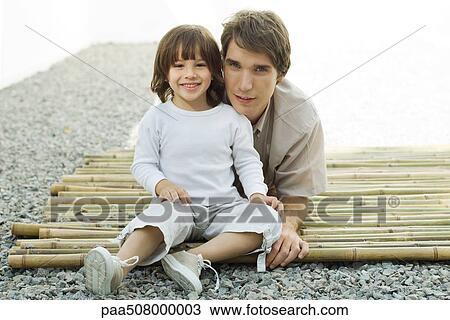Young man and son on bamboo together, both smiling at camera View Large Photo Image Stock Image - Young man and son on bamboo together, both smiling at camera. Fotosearch