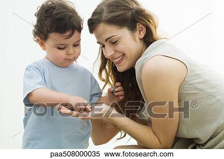 Young mother showing pebbles to curious toddler View Large Photo Image Stock Photography - Young mother showing pebbles to curious toddler. Fotosearch