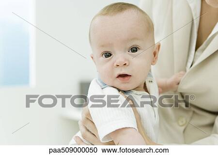 Infant sitting on mother's lap, looking at camera, cropped View Large Photo Image Stock Image - Infant sitting on mother's lap, looking at camera, cropped. Fotosearch