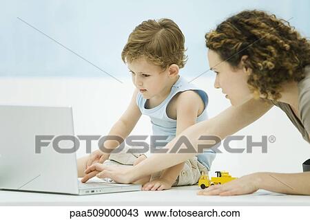 Mother and young son using laptop computer together View Large Photo Image Stock Image - Mother and young son using laptop computer together. Fotosearch