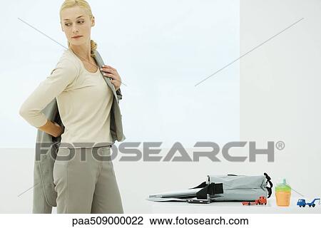 Professional woman dressing, looking over shoulder, sippy cup and toys next to bag View Large Photo Image Stock Image - Professional woman dressing, looking over shoulder, sippy cup and toys next to bag. Fotosearch