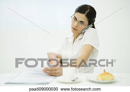 Professional woman sitting at breakfast table, holding baby, using cell phone and studying document View Large Photo Image Stock Image - Professional woman sitting at breakfast table, holding baby, using cell phone and studying document. Fotosearch
