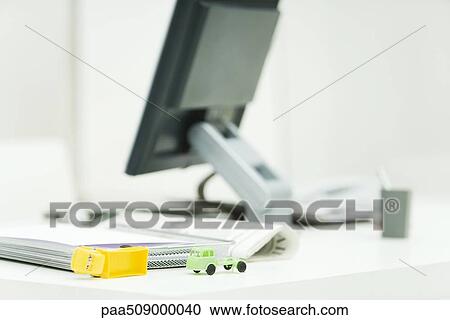 Stock Image - Toy trucks sitting on professional desk in office. Fotosearch