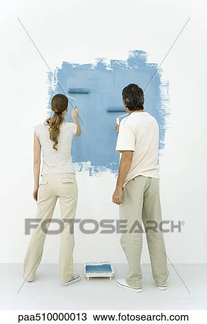 Couple painting wall blue using rollers, rear view View Large Photo Image Stock Image - Couple painting wall blue using rollers, rear view. Fotosearch