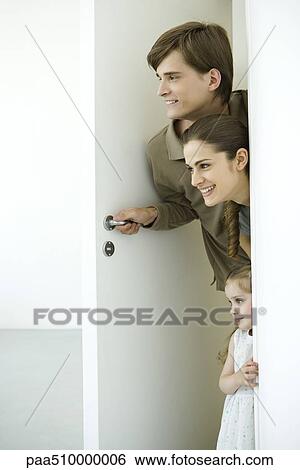 Stock Photograph - Family peeking in doorway. Fotosearch