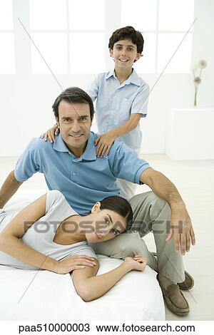 Family relaxing together, all smiling at camera View Large Photo Image Stock Image - Family relaxing together, all smiling at camera. Fotosearch
