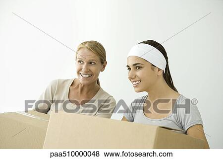 Mother and daughter holding cardboard boxes, both smiling and looking away View Large Photo Image Stock Photo - Mother and daughter holding cardboard boxes, both smiling and looking away. Fotosearch