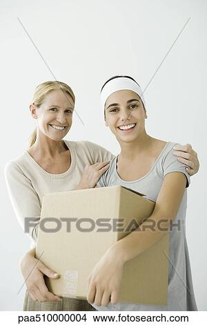 Young female holding cardboard box, mother holding her shoulders View Large Photo Image Picture - Young female holding cardboard box, mother holding her shoulders. Fotosearch
