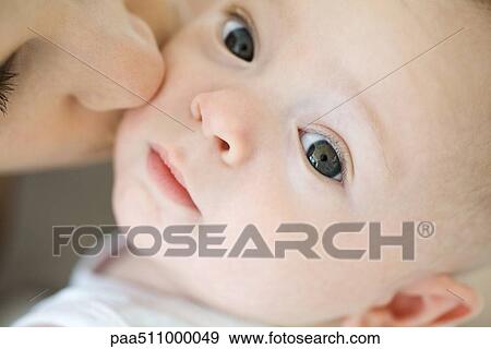 Infant looking at camera, mother kissing cheek, cropped View Large Photo Image Stock Photo - Infant looking at camera, mother kissing cheek, cropped. Fotosearch