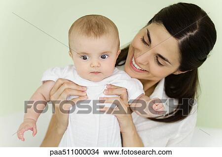 Picture - Mother holding baby, smiling. Fotosearch