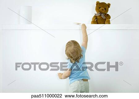 Toddler reaching for lollipop on high shelf, rear view View Large Photo Image Stock Image - Toddler reaching for lollipop on high shelf, rear view. Fotosearch