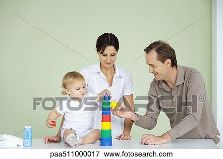 Toddler stacking plastic toys, parents watching View Large Photo Image Stock Photo - Toddler stacking plastic toys, parents watching. Fotosearch
