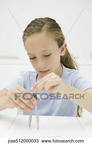 Stock Image - Girl drawing with compass. Fotosearch