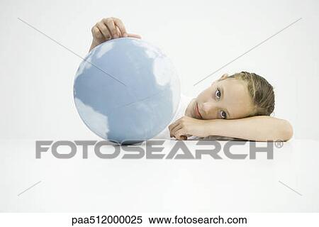 Girl holding globe, head resting on arms, looking at camera View Large Photo Image Stock Photography - Girl holding globe, head resting on arms, looking at camera. Fotosearch