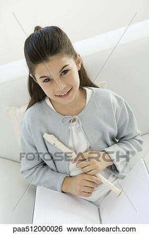 Girl holding recorder, smiling at camera, high angle view View Large Photo Image Stock Photograph - Girl holding recorder, smiling at camera, high angle view. Fotosearch