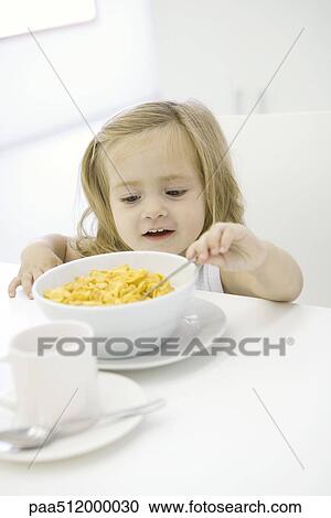 Toddler girl reaching to eat bowl of cereal View Large Photo Image Stock Image - Toddler girl reaching to eat bowl of cereal. Fotosearch