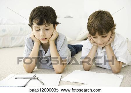 Two boys lying on floor, studying homework View Large Photo Image Stock Photography - Two boys lying on floor, studying homework. Fotosearch