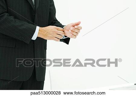 Businessman in suit, adjusting cuff, cropped view View Large Photo Image Stock Photo - Businessman in suit, adjusting cuff, cropped view. Fotosearch
