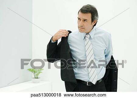 Man in suit putting on jacket, looking away View Large Photo Image Stock Photo - Man in suit putting on jacket, looking away. Fotosearch