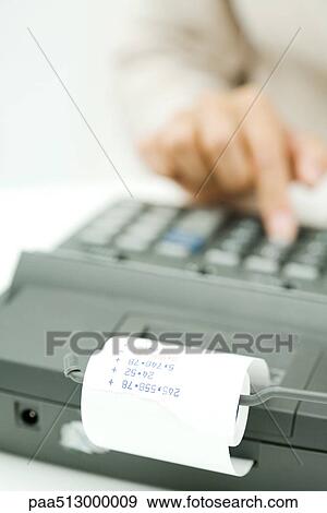 Stock Photo - Person using adding machine, cropped view. Fotosearch