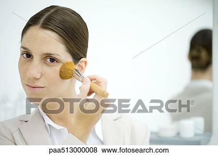 Professional woman applying blush, smiling at camera View Large Photo Image Stock Photo - Professional woman applying blush, smiling at camera. Fotosearch