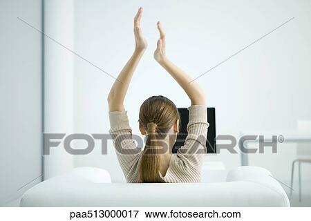 Woman watching TV, arms raised in the air, rear view View Large Photo Image Stock Photo - Woman watching TV, arms raised in the air, rear view. Fotosearch