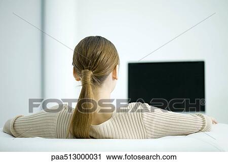 Woman watching TV, rear view View Large Photo Image Stock Image - Woman watching TV, rear view. Fotosearch