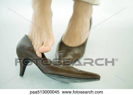 Woman wearing high heels, one shoe off, cropped view of feet View Large Photo Image Stock Photography - Woman wearing high heels, one shoe off, cropped view of feet. Fotosearch