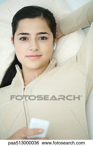 Young woman listening to MP3 player, portrait View Large Photo Image Stock Photograph - Young woman listening to MP3 player, portrait. Fotosearch