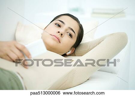 Young woman lying on back, listening to MP3 player View Large Photo Image Stock Photograph - Young woman lying on back, listening to MP3 player. Fotosearch