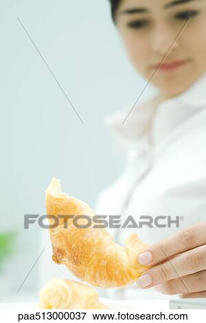 Young woman picking up croissant, low angle view View Large Photo Image Stock Photo - Young woman picking up croissant, low angle view. Fotosearch