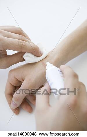 Stock Photo - Doctor cleaning wound on patient's hand, cropped view. Fotosearch