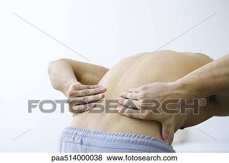 Man bending over, holding lower back, cropped view View Large Photo Image Stock Photo - Man bending over, holding lower back, cropped view. Fotosearch