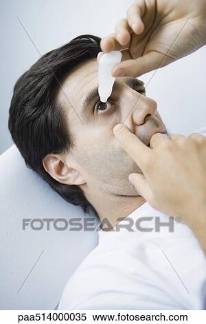 Man reclining, putting eyedrops in one eye View Large Photo Image Stock Photography - Man reclining, putting eyedrops in one eye. Fotosearch