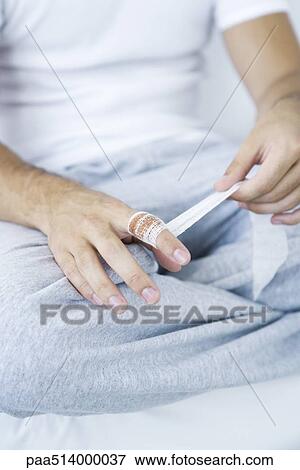 Man wrapping gauze around injured finger, cropped view View Large Photo Image Stock Photo - Man wrapping gauze around injured finger, cropped view. Fotosearch