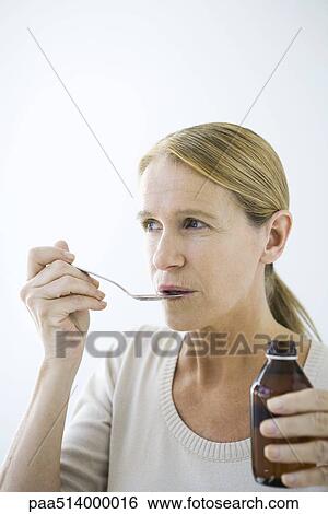 Mature woman taking a spoonful of medicine View Large Photo Image Stock Photograph - Mature woman taking a spoonful of medicine. Fotosearch
