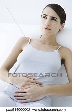 Woman reclining, holding stomach View Large Photo Image Stock Image - Woman reclining, holding stomach. Fotosearch
