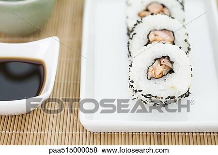 Stock Photo - Cropped view of pieces of sushi with soy sauce, close-up. Fotosearch