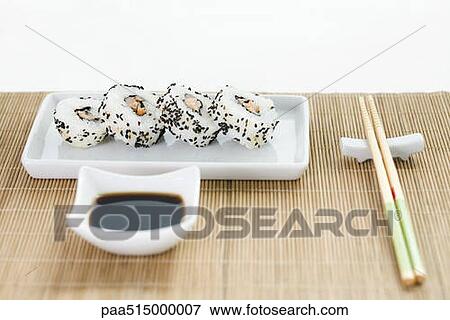 Maki sushi with soy sauce and chopsticks arranged on bamboo placemat View Large Photo Image Stock Photo - Maki sushi with soy sauce and chopsticks arranged on bamboo placemat. Fotosearch