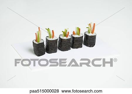 Row of maki sushi arranged in row on cutting board View Large Photo Image Stock Photo - Row of maki sushi arranged in row on cutting board. Fotosearch