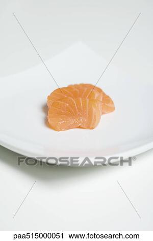 Stock Image - Slices of salmon sashimi on sushi plate. Fotosearch